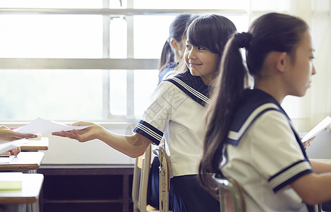 向后传递考卷的女同学背景图片