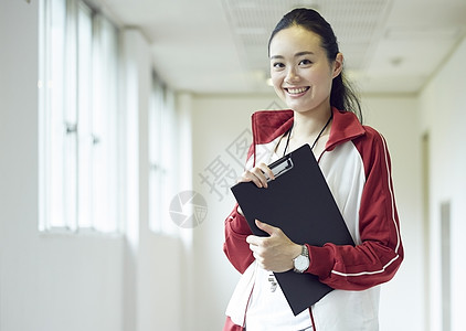 楼道间手持教案微笑的女老师图片