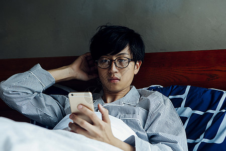 躺床上看手机的男人图片