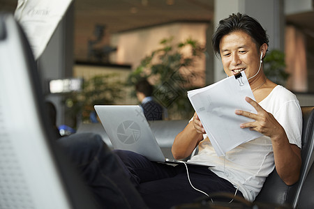 在机场用笔记本电脑工作的男性图片