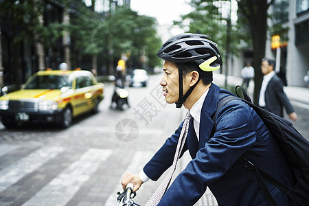 骑自行车过斑马线的西装男性图片