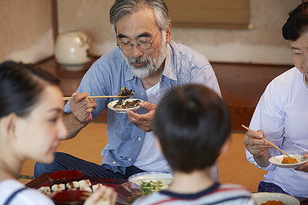 日式房屋中吃午饭的4人图片