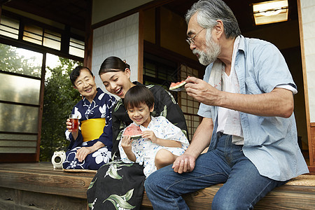 日式房屋中吃西瓜乘凉的4人图片