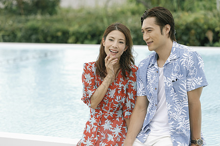 美女和帅哥在泳池畔旁散步休假日本人高清图片素材