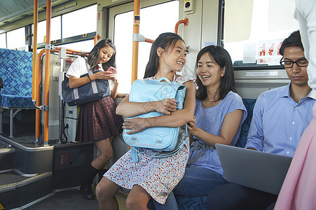 公交车上坐在母亲腿上的小学生公车高清图片素材