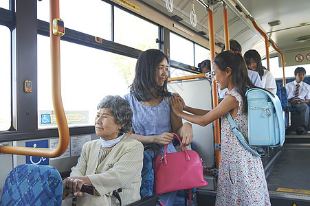 妈妈和女儿一起乘坐公交车护栏高清图片素材