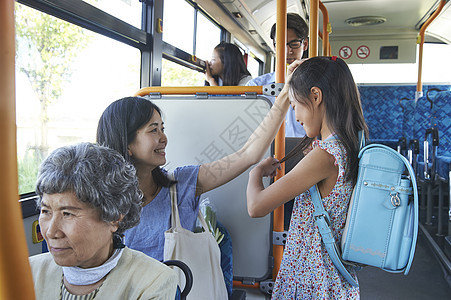 妈妈和女儿一起乘坐公交车汽车高清图片素材