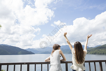 塞里木湖夏日出游的闺蜜在湖边看风景背景