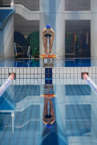 站在跳板上准备起跳的游泳运动员背景图片