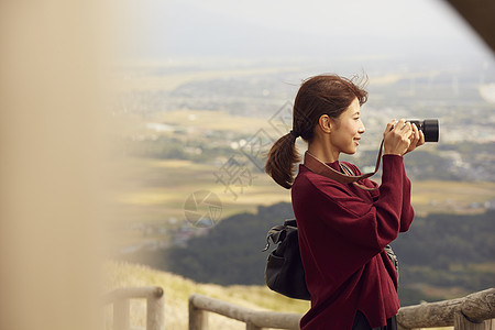 女性青年在户外旅游观光拍照高清图片