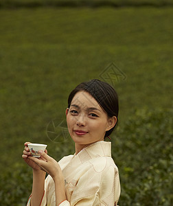 手捧茶杯的优雅妇女图片