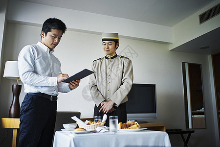 酒店客房服务人员送早餐进房间并收款图片