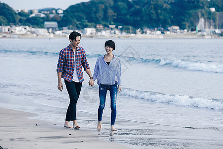 海边漫步在海边手牵着手的情侣背景