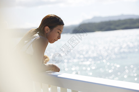 旅途中的女性走在海面大桥上看风景图片