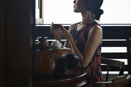 女人在茶馆窗台边品茶看窗外图片