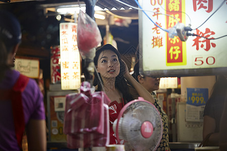 在夜市逛街的女游客图片