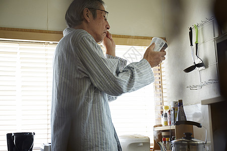 独居的老人在厨房扶着眼镜看食品包装说明图片