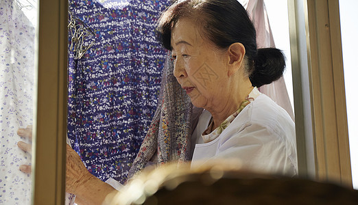 独居老妇人在洗衣房晾衣服图片