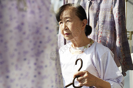 独居老妇人在洗衣房晾衣服时看外面图片