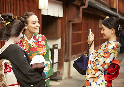 东茶屋街穿着和服与艺伎合影的外国游客背景