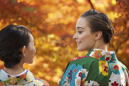 和服女人和外国游客一起观赏红枫叶图片