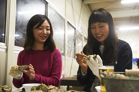 两个女人在吃烤生蚝图片