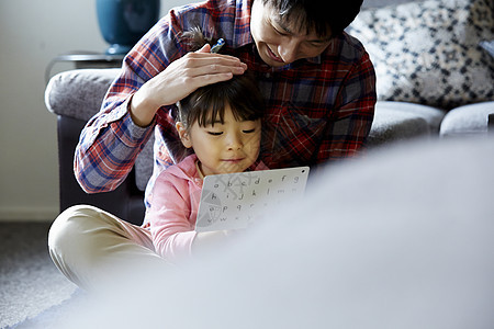 爸爸把女儿抱在怀里教她英语图片