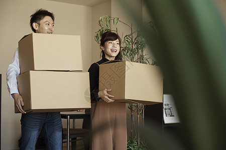 在公寓新家搬着纸箱的情侣图片