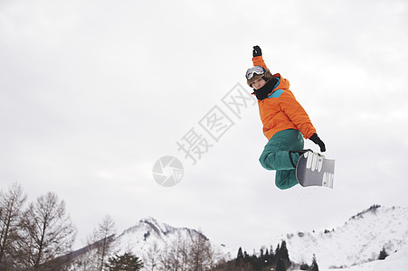 滑雪时跳起的青年男性图片