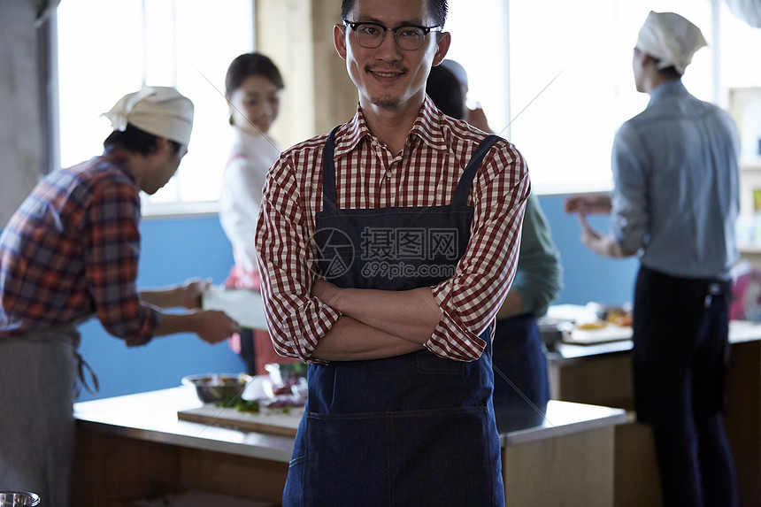 在学习烹饪的烹饪班成员在看镜头图片