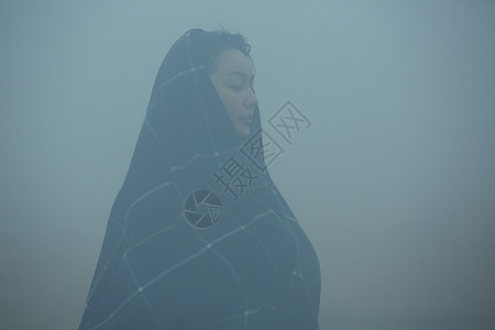 披着披肩站在迷雾中的女性图片