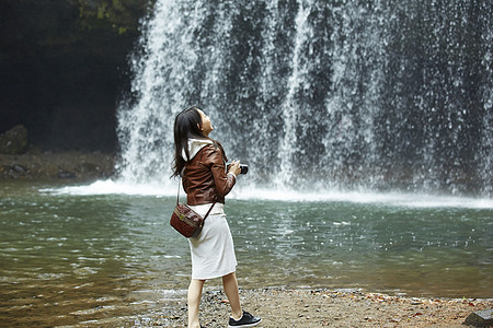 站在瀑布前的女性摄影师图片