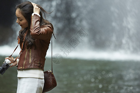 清澈的小溪边拿着相机的女人外面高清图片素材