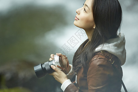 外出旅行拿着相机的年轻女性水花高清图片素材
