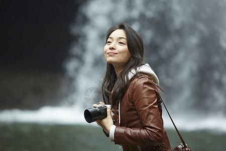外出旅行拿着相机的年轻女性河流源头高清图片素材