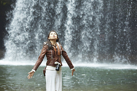 欣赏瀑布的年轻女性清溪高清图片素材