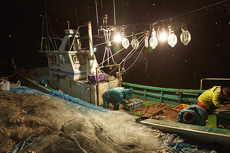 夜晚搬运新鲜鱼类的渔民们图片