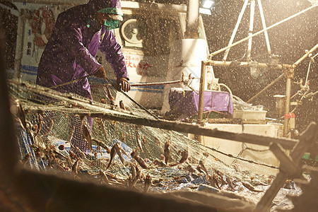 雨夜里拉着渔网的渔民们图片