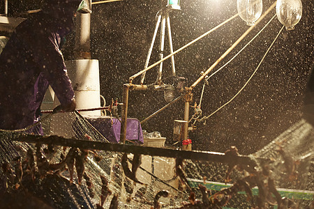 雨夜里拉着渔网的渔民们图片
