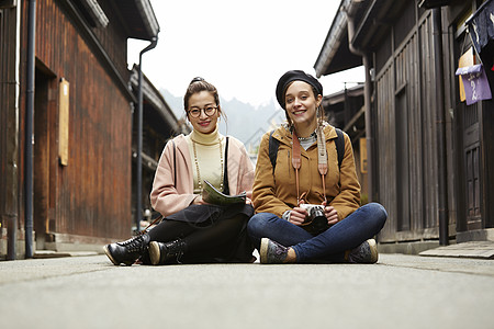 带着相机外国妇女和拿着地图的日本妇女在老街道采风岐阜县图片