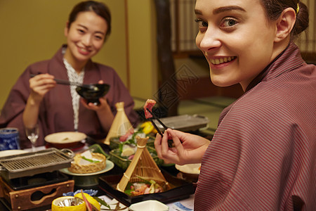 穿着现代和服享受美食的两个女人图片