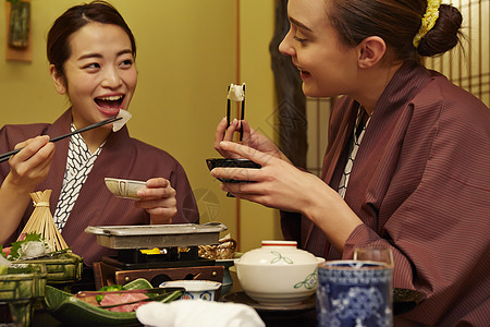 穿着现代和服享受美食的两个女人高清图片