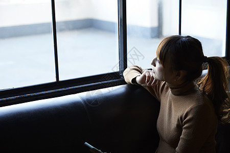 看着窗外的女人看着在窗外思考的女性背景