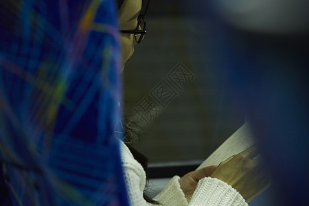 夜晚巴士上阅读的女性侧脸图片