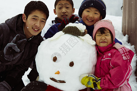 和雪人开心合影的孩子们图片