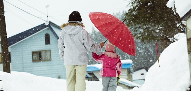 雪中散步撑着伞的母女图片