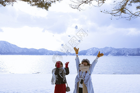 雪景区湖畔玩耍的少女们图片