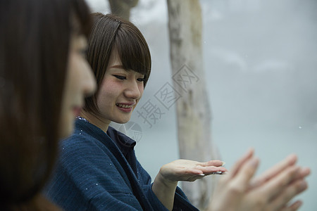 冬季雪天户外泡温泉的少女图片