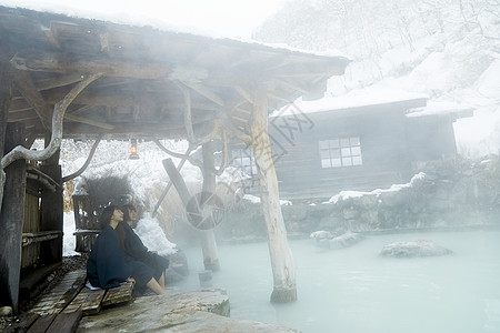 冬季雪天户外泡温泉的少女高清图片