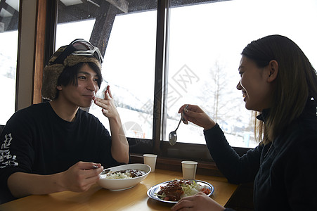 滑雪餐厅享用美食的年轻情侣图片